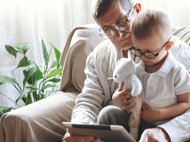 A grandfather teaching his grandson to read.