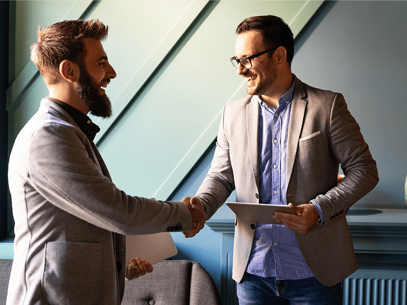 Two men shaking hands over a business deal.